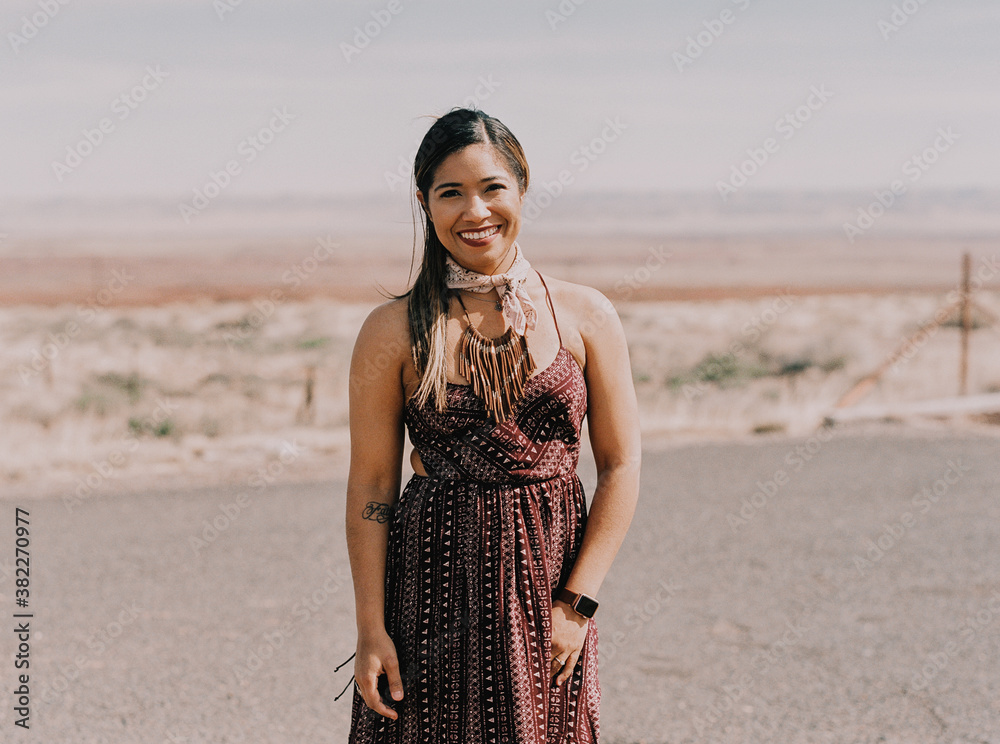 A portrait of a woman standing in the dry Arizona desert.